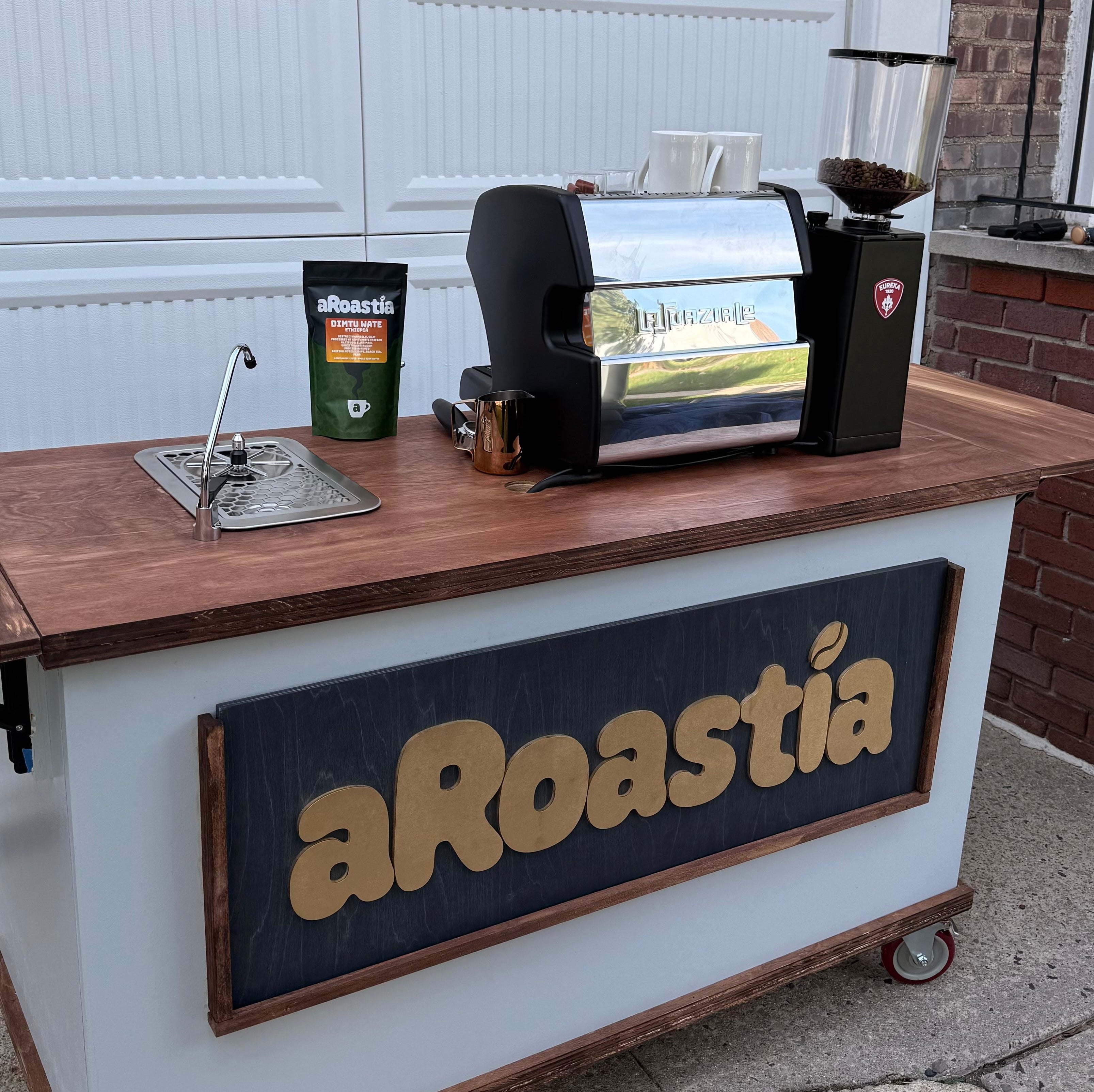 Portable coffee station with aRoastia branding on a wooden counter.