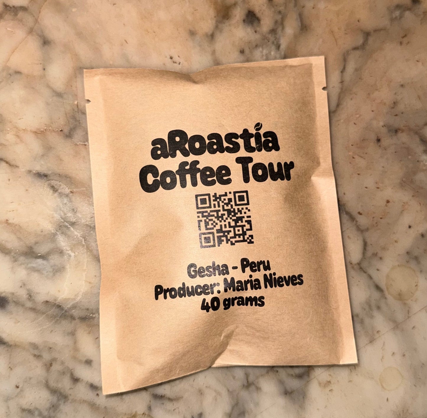Coffee package from aRoastia Coffee Tour on a marble surface