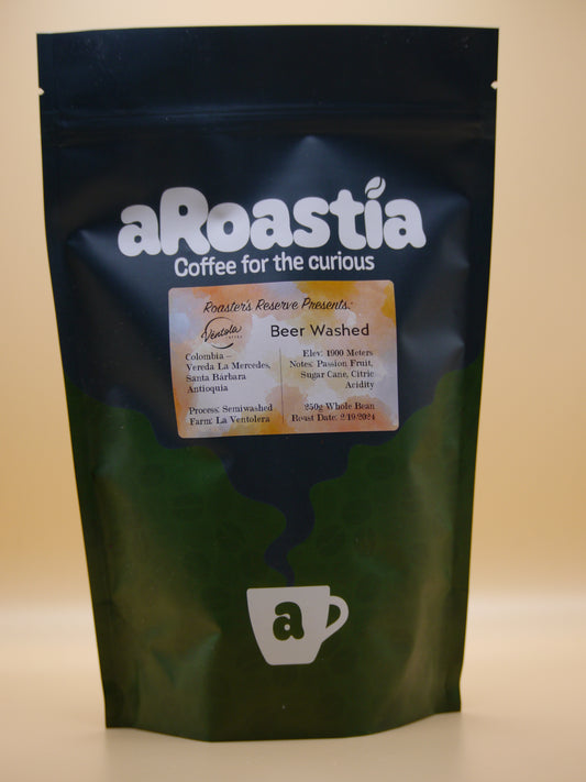 A photo of a bag of Beer Washed, a washed processed coffee offered by aRoastia. The bag has an orange colored label on it, with information about the coffee. The coffee beans were picked at an elevation of 1900 meters above sea level, and went through a semiwashed process.